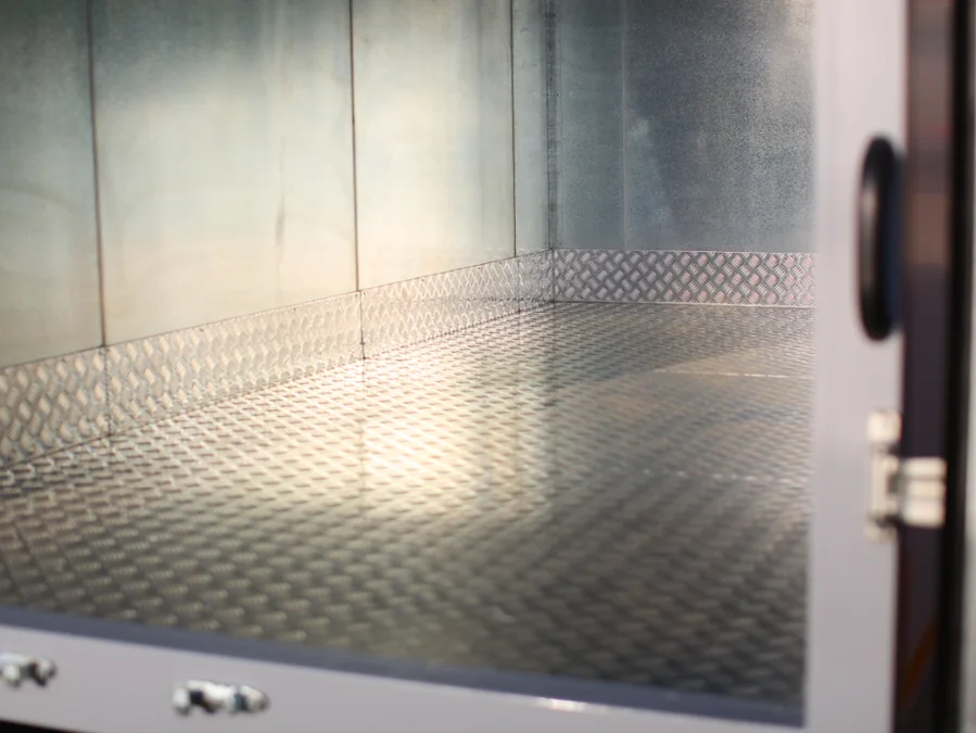 Chequered aluminium floor in a COND body