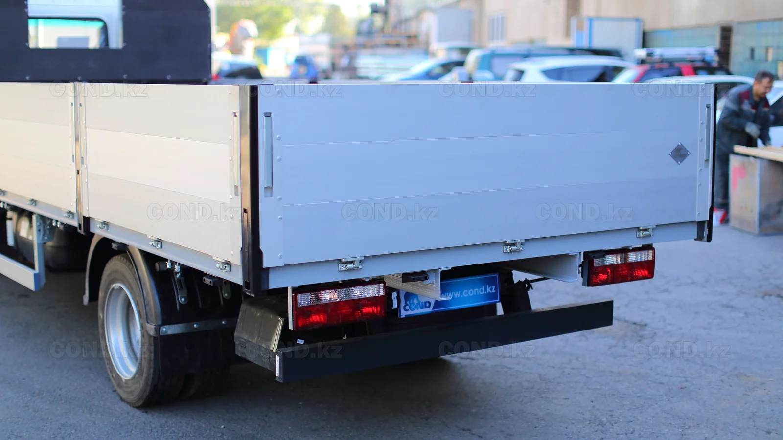 Flatbed platform on a JAC N56 chassis — rear three-quarter view, the platform with boards raised — COND