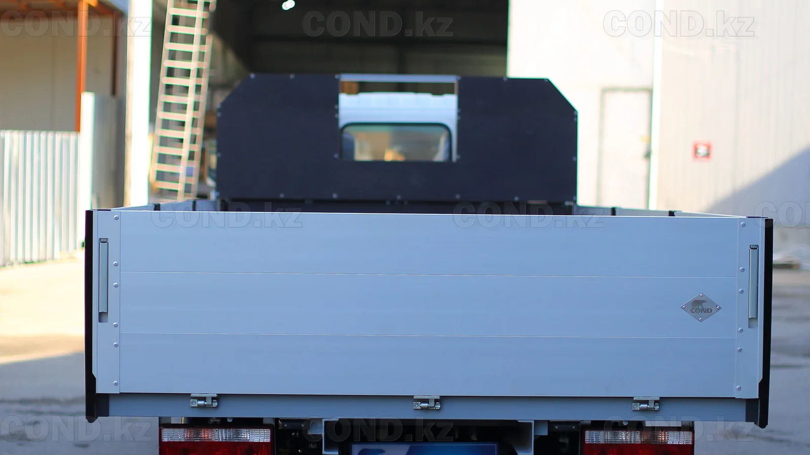 Flatbed platform on a JAC N56 chassis — the tailboard folded down — COND
