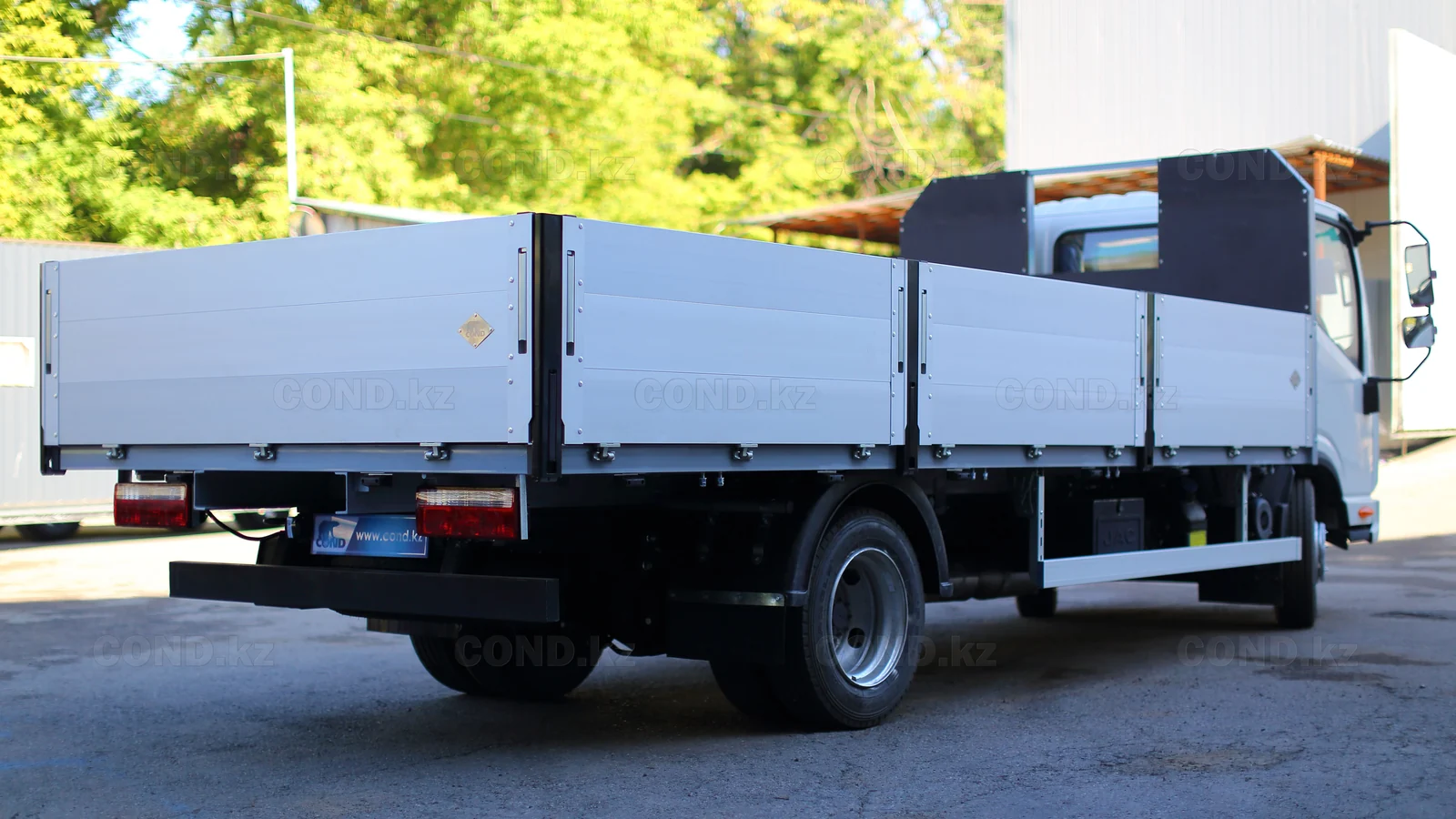 Flatbed platform on a JAC N56 chassis — rear three-quarter view from the right — COND