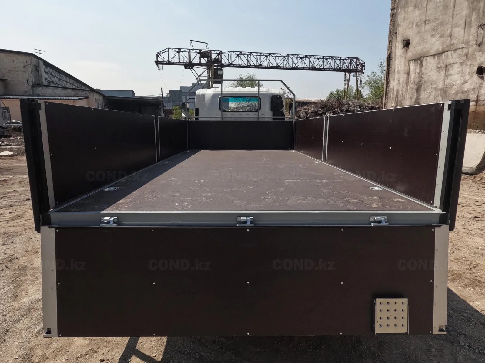 Flatbed body on a JAC N80 chassis — the sides dropped: the laminated plywood deck and the side hinges — COND