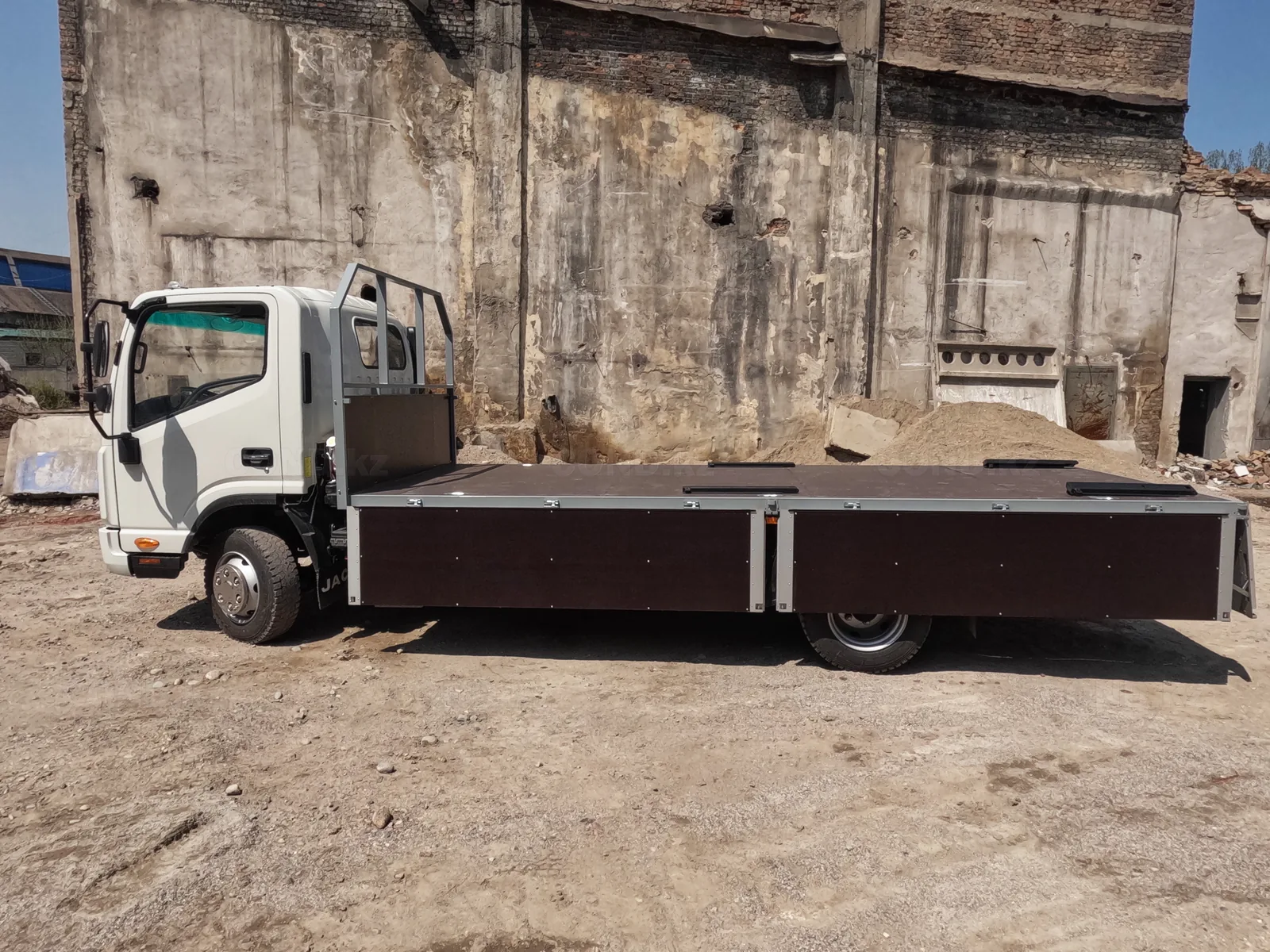 Flatbed body on a JAC N80 chassis — a side view with the sides dropped along the full length — COND