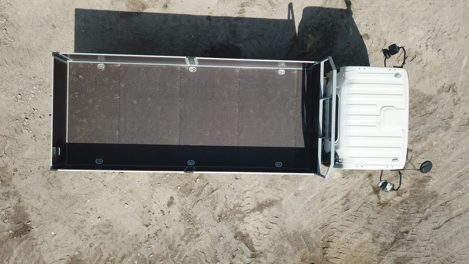 Flatbed body on a JAC N80 chassis — a top view: the deck and the flush lashing rings in the sides — COND