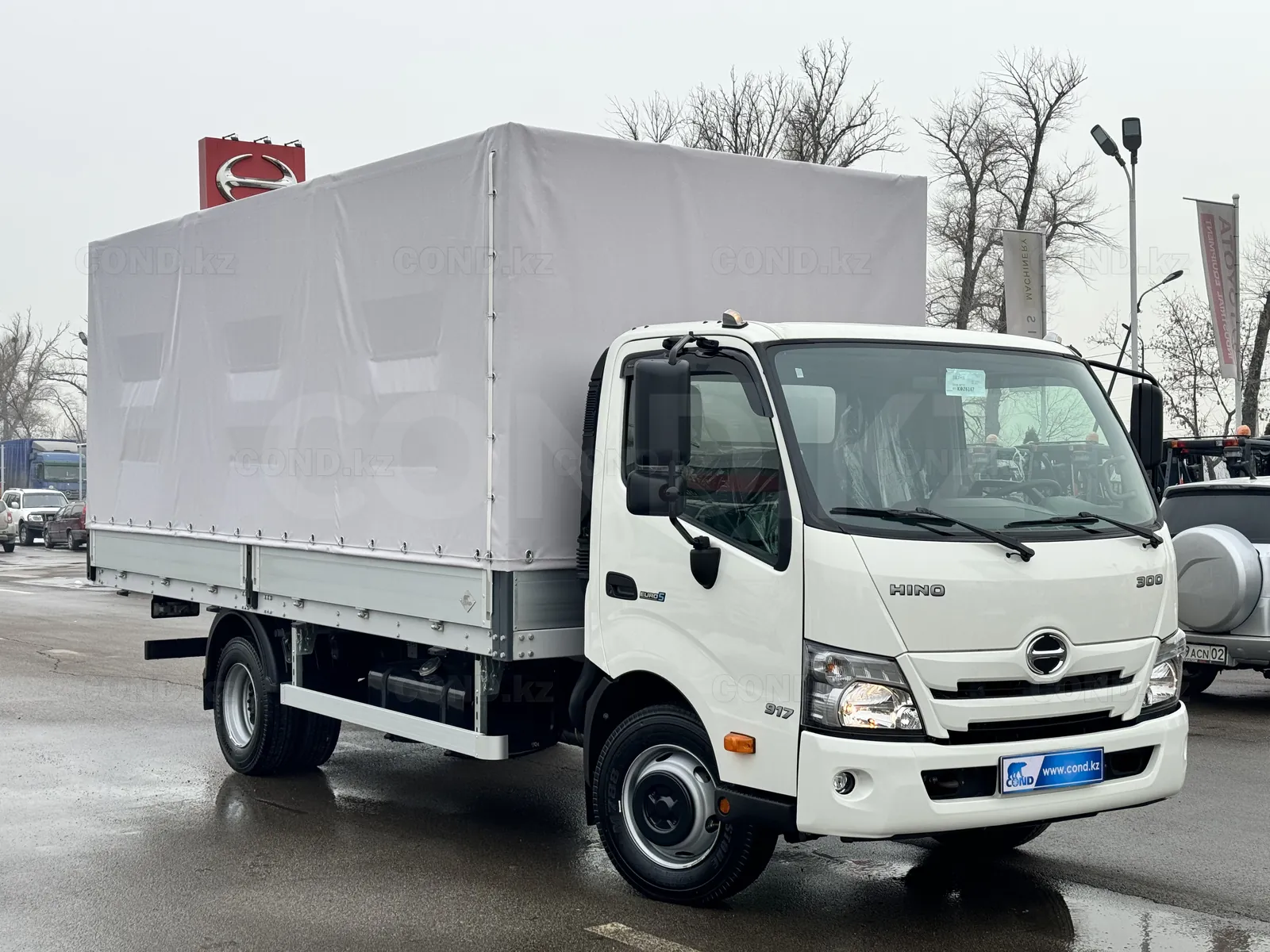 Flatbed body with a curtain HINO 300 Astana — front three-quarter view on the right — COND