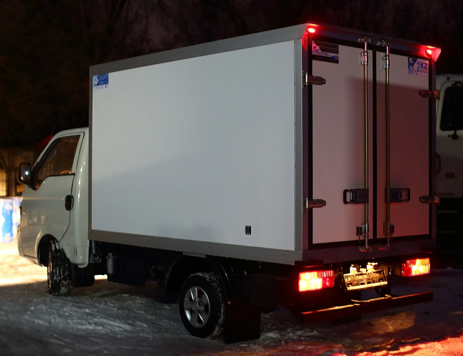 JAC X200 шассиіндегі изотермиялық фургон — шанақ бүйірден және габарит шамдары жанған артқы есіктер — COND